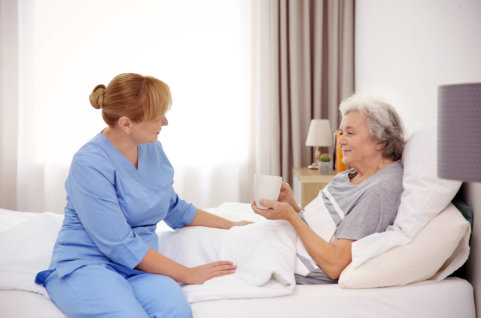 nurse taking care of elder in bed