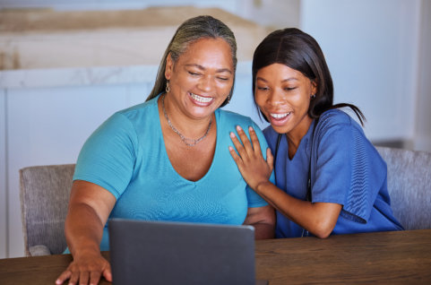 nurse and elder using laptop