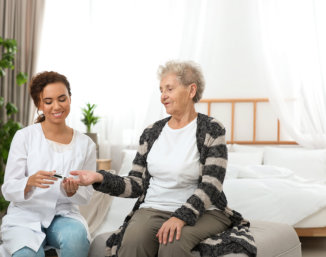 nurse accompaying elder lying in bed
