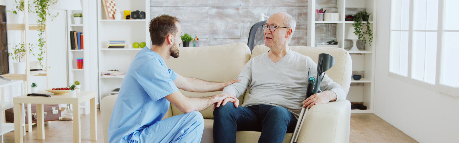 nurse accompanying elder sitting in the couch