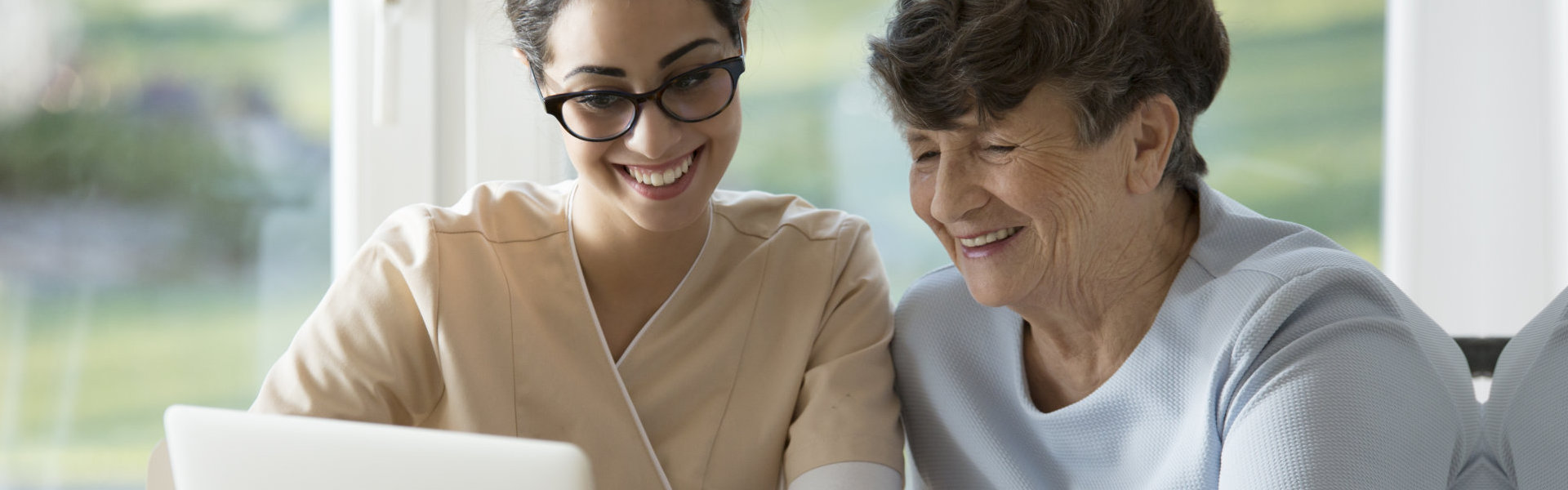 nurse and elder using laptop