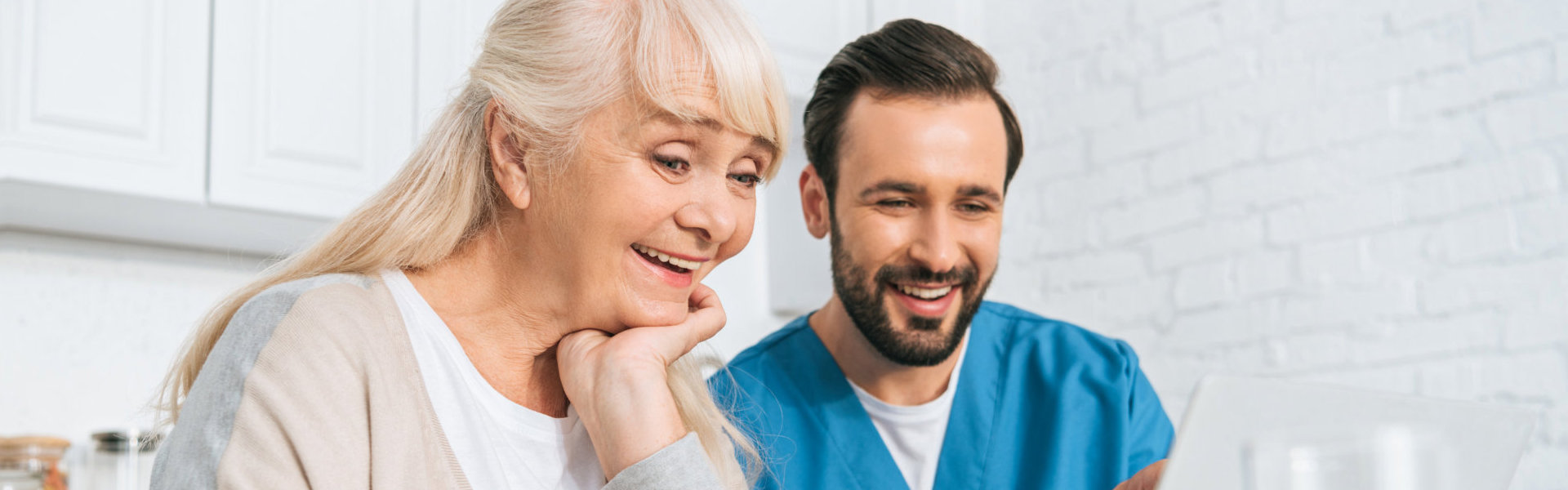 nurse and elder using laptop