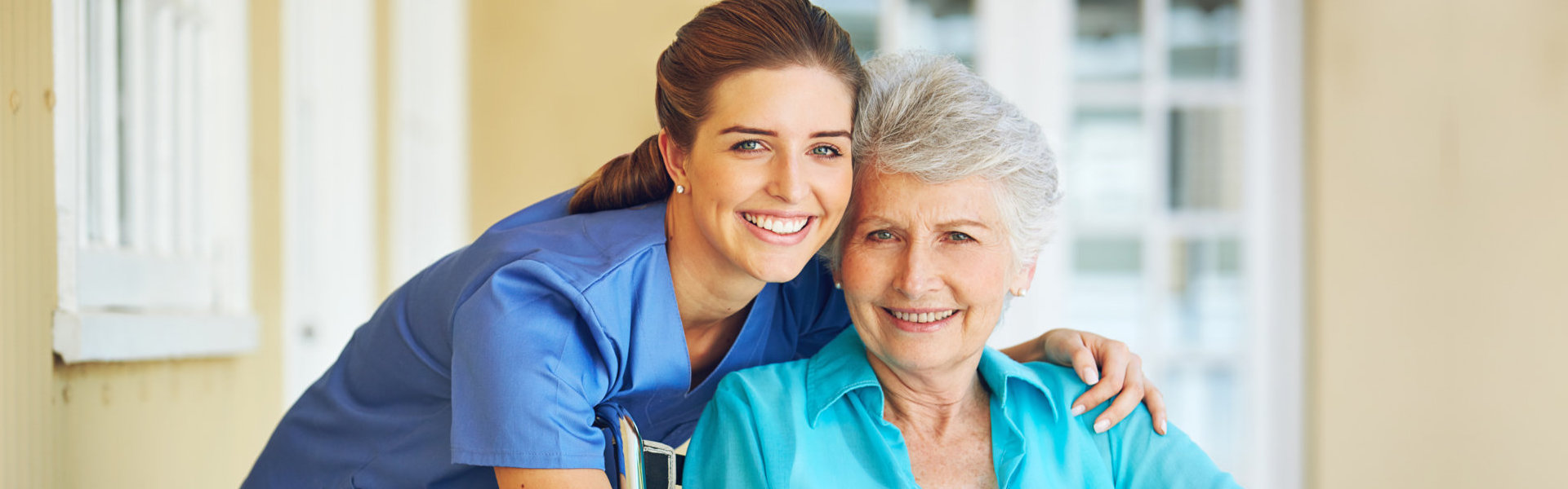 nurse hugging elder and smiling